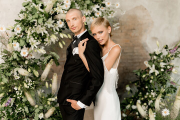 Young beautiful happy couple hugging and smiling near the arch