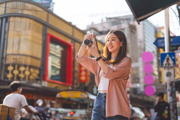 Happy adult asian woman traveler using digital camera travel in southeast asia at outdoors on day