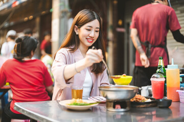 Traveler woman enjoy eating street food spicy thai tasty menu travel at chinatown Yaowarat, Bangkok, Thailand