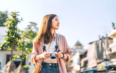 Happy adult asian woman traveler using digital camera travel in southeast asia at outdoors on day