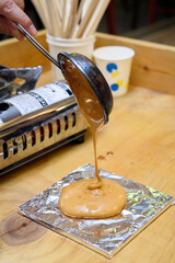 Making Dalgona, a Korean snack
