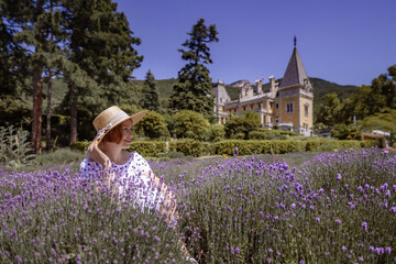 A woman is sitting in a field of purple flowers