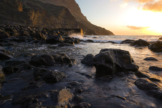 Angler standing on a breakwater at sunset - Powered by Adobe
