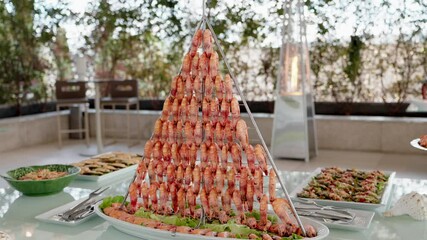 close up of pyramid shrimp tower at seafood buffet in refined indoor event setting