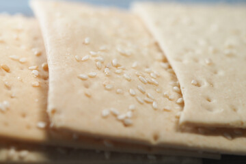Sesame crackers displayed on a wooden tray in a warm kitchen
