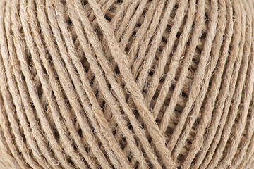 A close-up shot showcases a tightly coiled ball of natural twine, displaying its intricate texture.