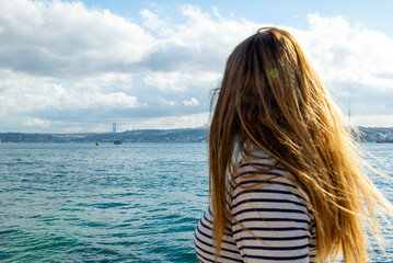 Girl with long hair looking at the Bosphorus. High quality photo