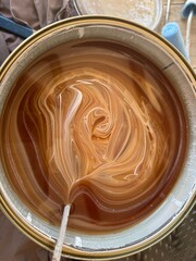 Mixing paint in can to create the desired color.