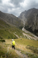 Solo female traveler trekking through the scenic mountainous landscape of Ala Archa National park...