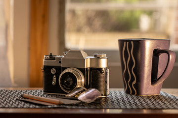 Vintage Film Camera with Mug and Pen on Desk in Natural Lighting