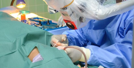 Ear surgery by microsurgery, surgeon with surgical instruments, The doctor is operating the ear to...