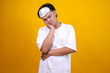 Asian Guy in Pajamas Pressing His Cheek with Hand Looking Bored or Annoyed