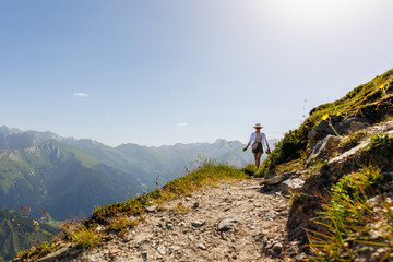 Scenic back view young adult woman  walk enjoy exploring scenic alpine austrian mountain peak...