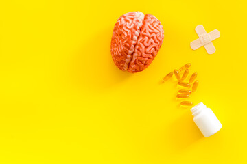 Human brain model with medical pills and patches, top view. Mental health concept.