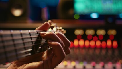Musician singer recording a new song on his electro acoustic guitar, creating new music in...