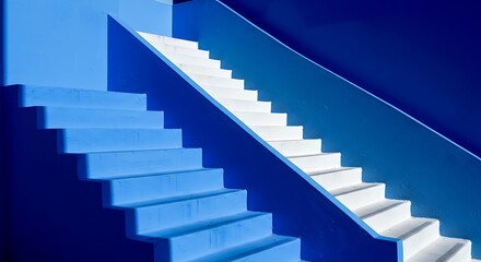 Fototapeta premium Colorfully painted staircase with contrast blues and whites. building shadows make this image an abstract background.