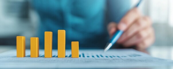 1. A close-up view of a hand holding a pen, analyzing a chart with yellow bars representing data metrics.