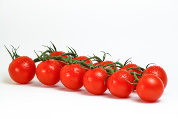Cherry tomatoes on a branch on a white background