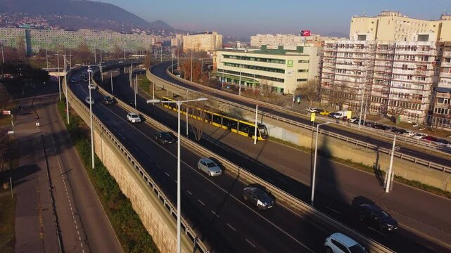 Golden hour light reflects on moving cars across Budapest&rsquo;s &Aacute;rp&aacute;d Bridge, scenic urban aerial