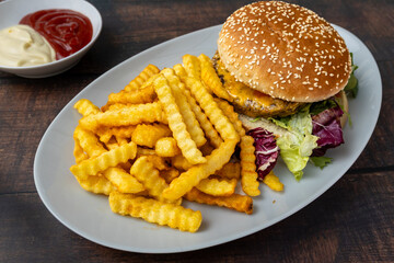 Cheeseburger with crinkle fries and ketchup.