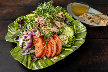 Fresh mixed salad with tuna, cucumbers, tomatoes, onions, and olives.