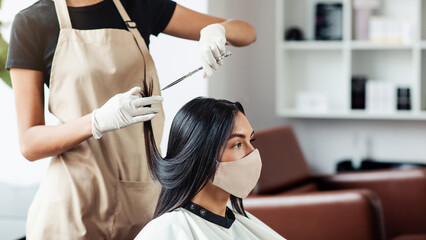 Working with safety. Hairdresser and customer in salon with medical masks during virus pandemic,...