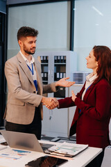 Happy businessman and businesswoman shaking hands at group board meeting. Professional business executive leaders making handshake agreement successful company trade partnership handshake concept.