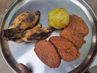 a plat of guava, banana and Thekua. It's commonly offered as prasad during the Chhath Puja festival in Bihar and other regions of India