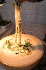 Freshly melted cheese pulled from pasta with herbs.