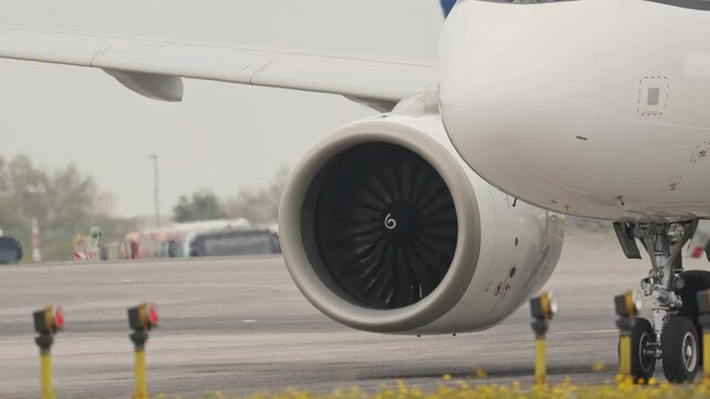 Large passenger airplane engine taxing on runway