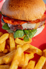 Hamburgers faits maison accompagnés de frites croustillantes, joliment présentés sur un plateau rouge dans un restaurant spécialisé.