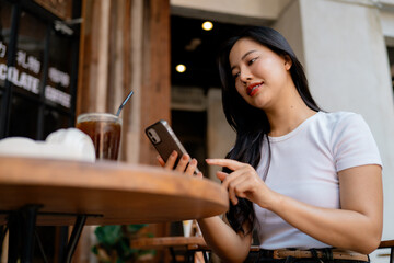 Young woman using smartphone while having breakfast at a cafe