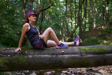 Woman sitting on forest log