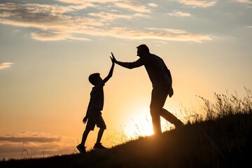 Silhouette father and son high five sunset gol