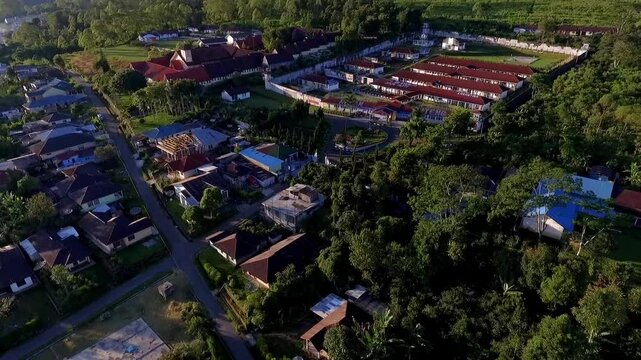 Aerial view of Ruteng town in Manggarai, East Nusa Tenggara, Indonesia, captured in the early morning light with mountain backdrop and dense residential areas.