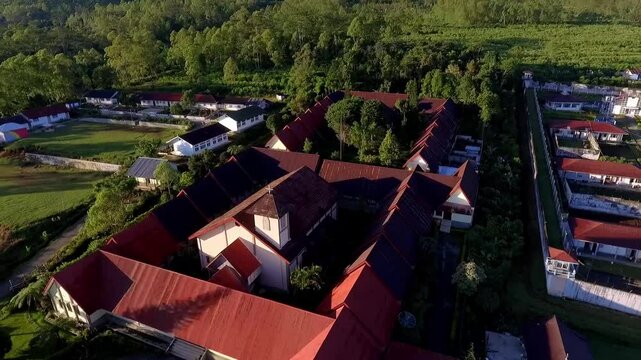 Aerial view of Ruteng town in Manggarai, East Nusa Tenggara, Indonesia, captured in the early morning light with mountain backdrop and dense residential areas.