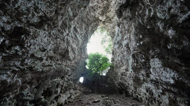 Slow pan inside Rizes Cave on the island of Ithaca , Greece. Large hole provides natural light
