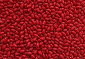 Bright red barberries scattered across a flat surface