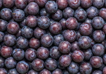 Fresh plums piled together against a plump purple background