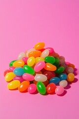 Obraz premium Vibrant pile of colorful jelly beans against a bright pink backdrop creating a playful and sweet visual mood perfect for candy themes
