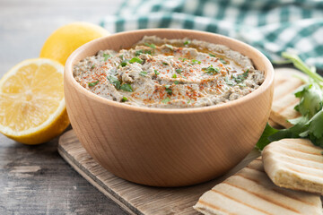 Traditional baba ganoush in bowl on wooden table