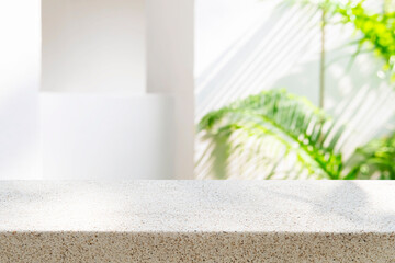 Tropical stone table top as mock up for product display montage on blurred white architecture...