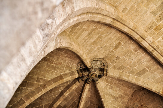 Historic vaulted stone ceiling with central keystone and radial arch ribs viewed from below for architectural detail