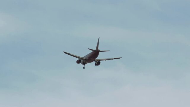 Commercial aircraft, hydraulic landing gear already released from fuselage. Civil jet prepares to land at airport. Twin-engine passenger plane final landing phase. Vacation trip