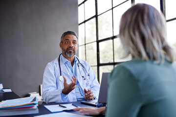 Serious indian doctor talking with patient about health therapy