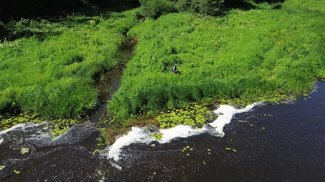Fisherman walking next to river in Latvia, fly fishing