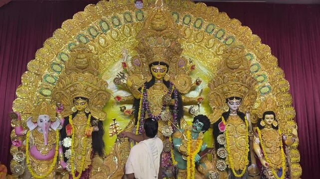 An Indian man offering prayers to Goddess Durga during puja in Kolkata.