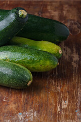 Green zucchini, fresh courgette squashes on rustic old wooden table background. closeup shot, copy space