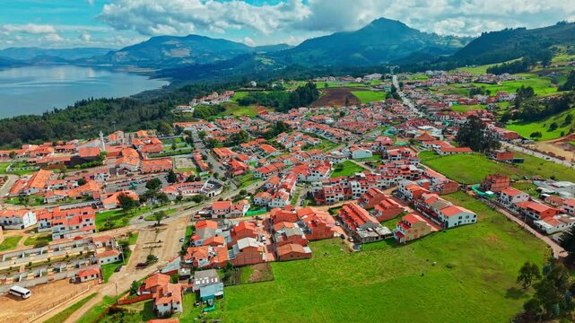 Aerial establishing fly above Guatavita village at daylight, Colombian travel landscape with Tomin&eacute; reservoir, lake and mountains