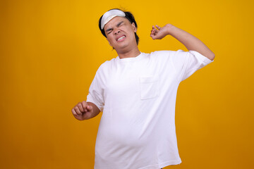 Asian Man in Pajamas Stretching Both Arms While Yawning, Morning Tiredness and Sleepiness